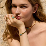 Detail shot of a model's hands adorned with rough-textured, interlocking band rings from the Halos line by Júlia Duran Jewelry.