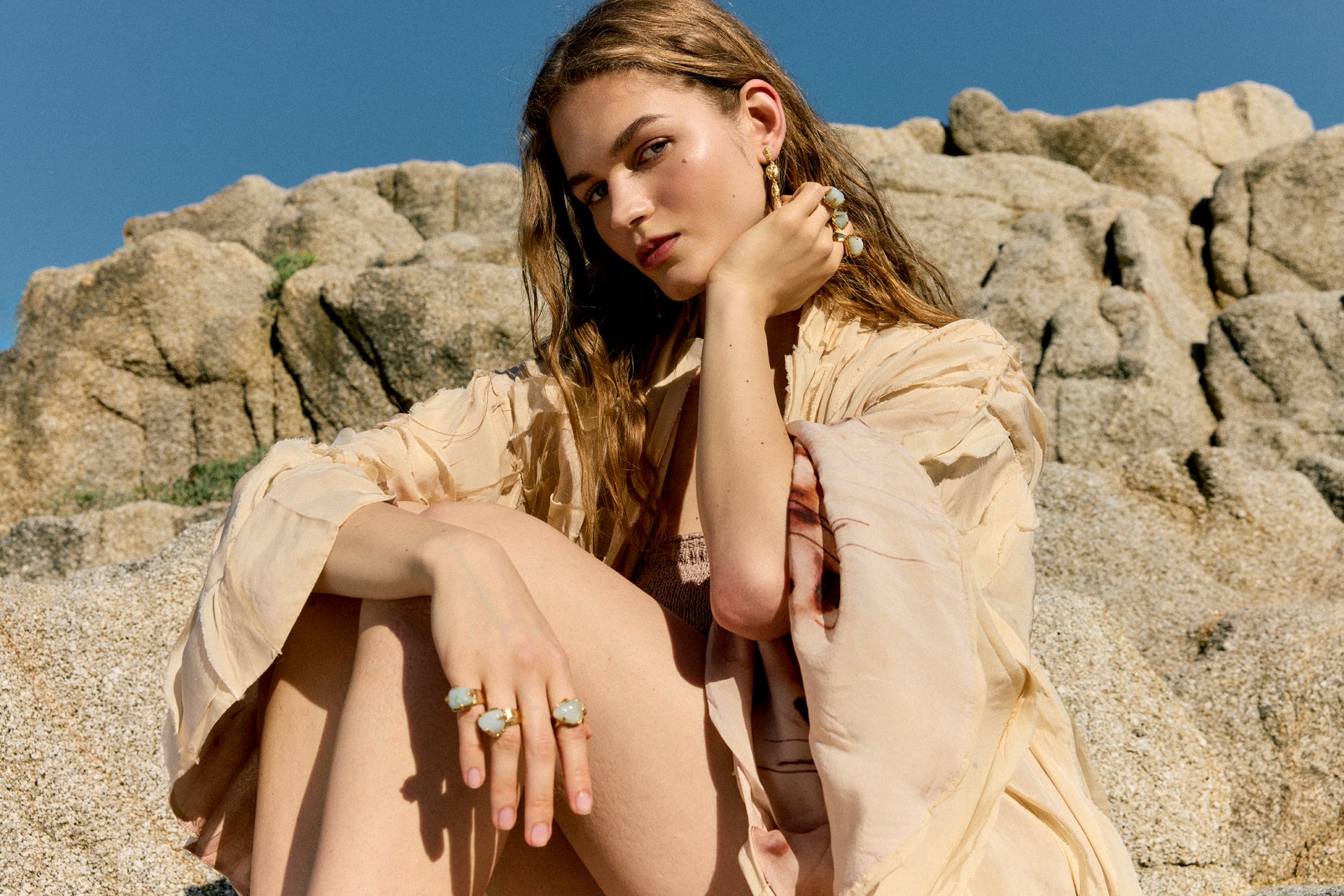 Side view of a model styling a rigid bracelet with imperfect, nature-inspired textures from the Halos collection.