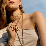 Detail shot of a model's neck and back showcasing an elegant chain with an organic texture from the Halos collection, jewelry made in Spain.