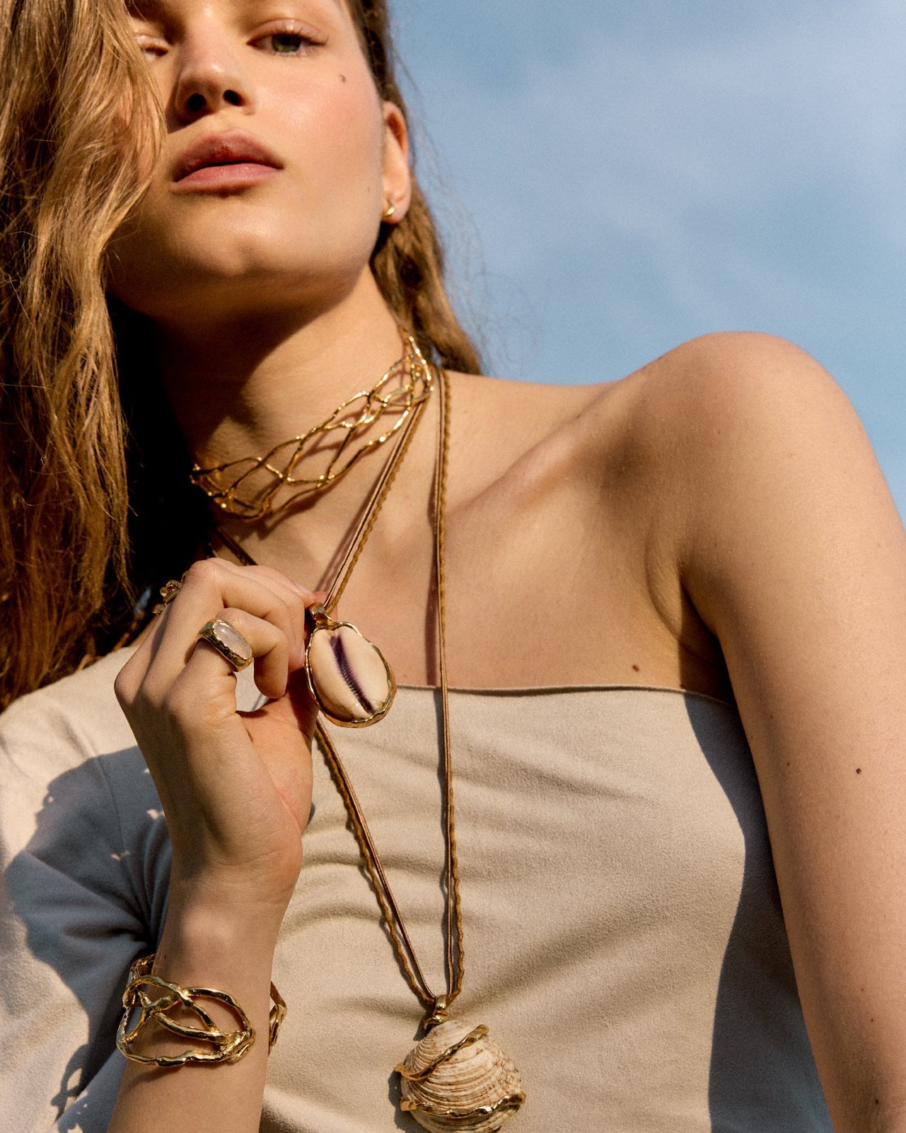 Detail shot of a model's neck and back showcasing an elegant chain with an organic texture from the Halos collection, jewelry made in Spain.