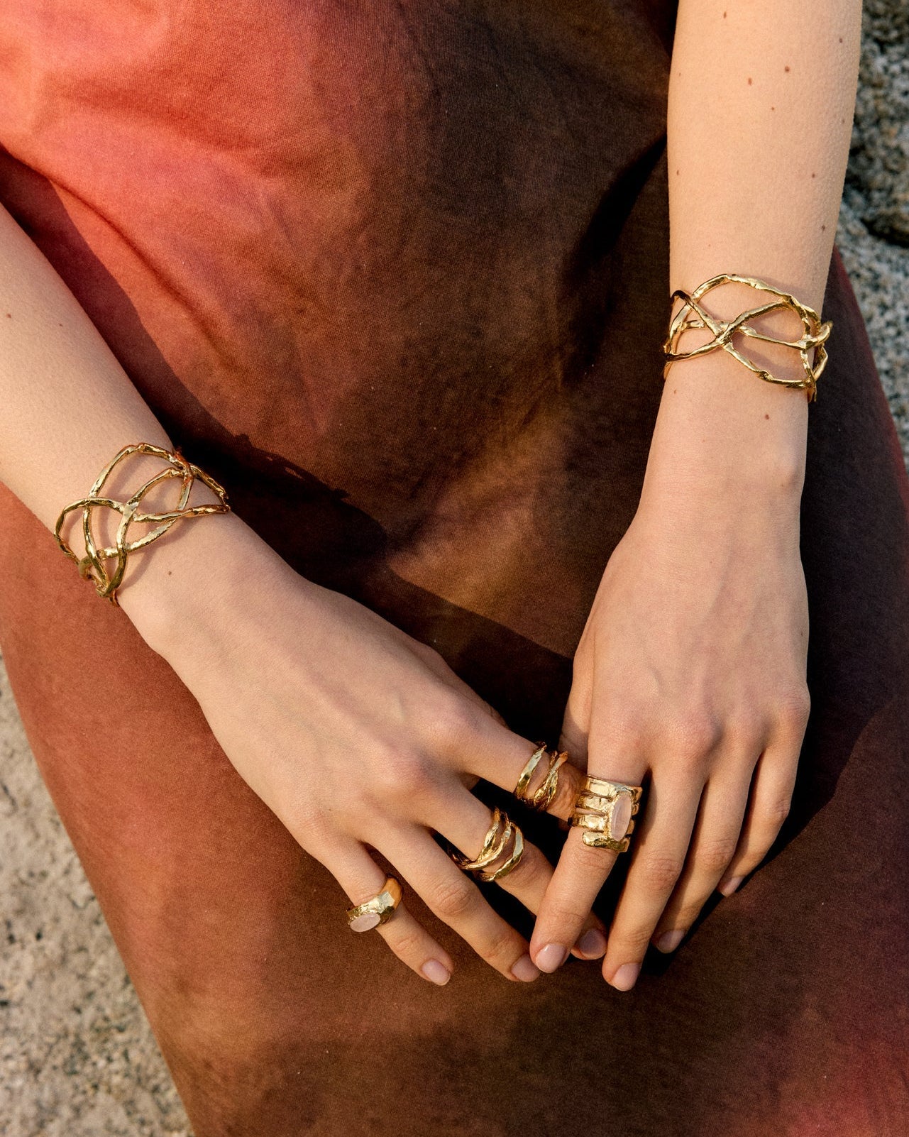 Detailed shot of hands with multiple stacked sterling silver rings from the Halos collection, featuring a minimalist and artisanal design.