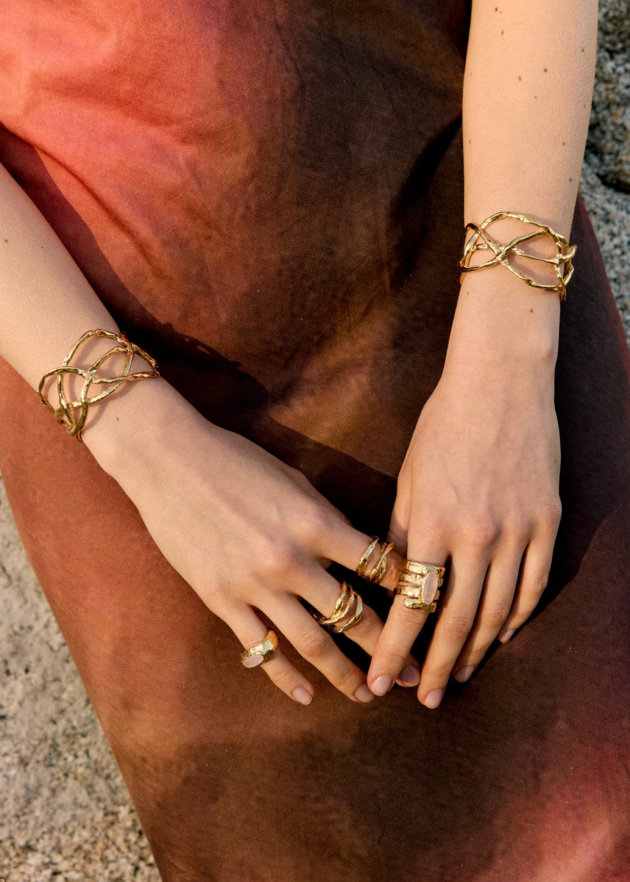 Detailed shot of hands with multiple stacked sterling silver rings from the Halos collection, featuring a minimalist and artisanal design.